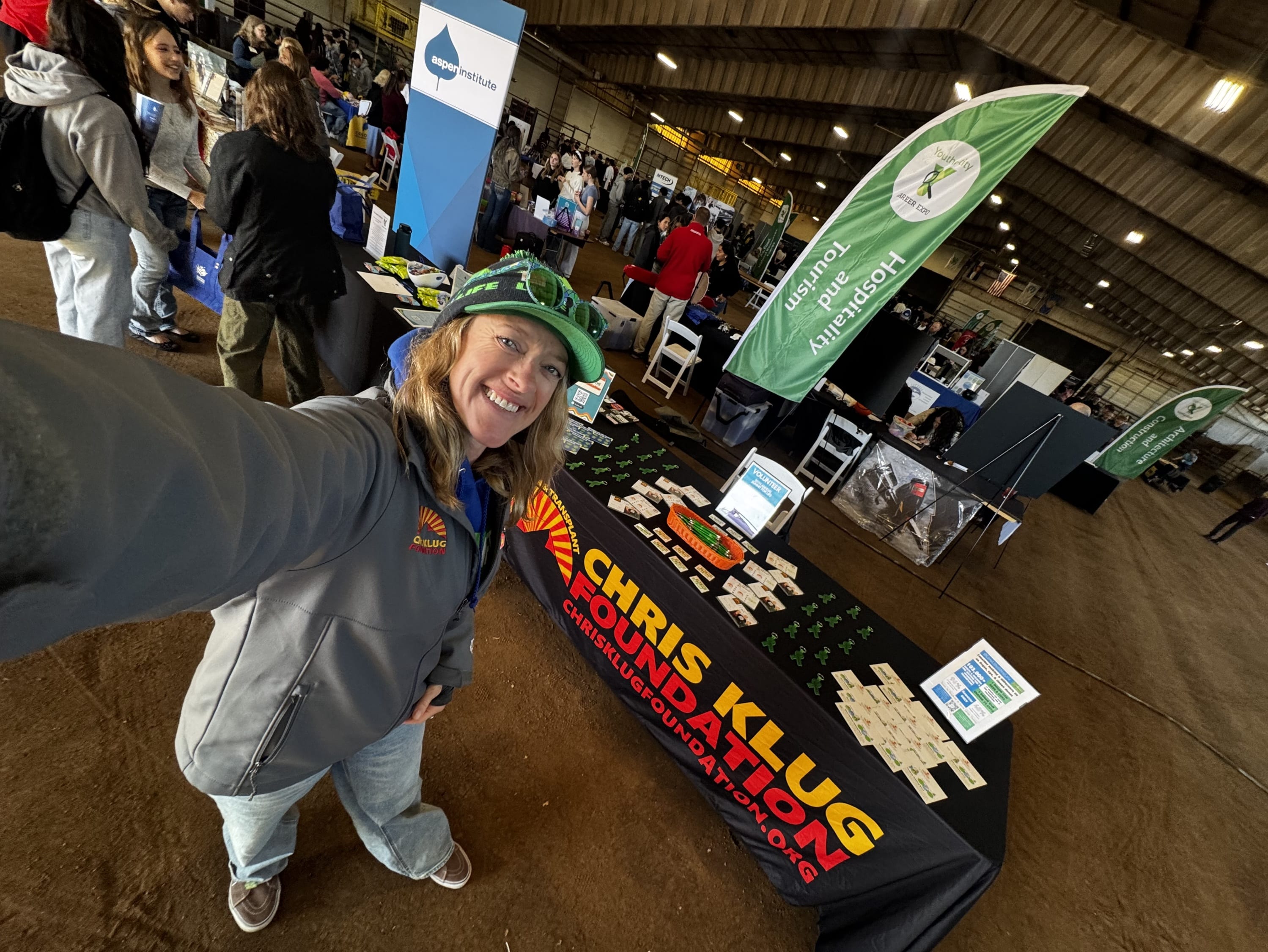 woman standing in front of CKF branded table at expo inside barn