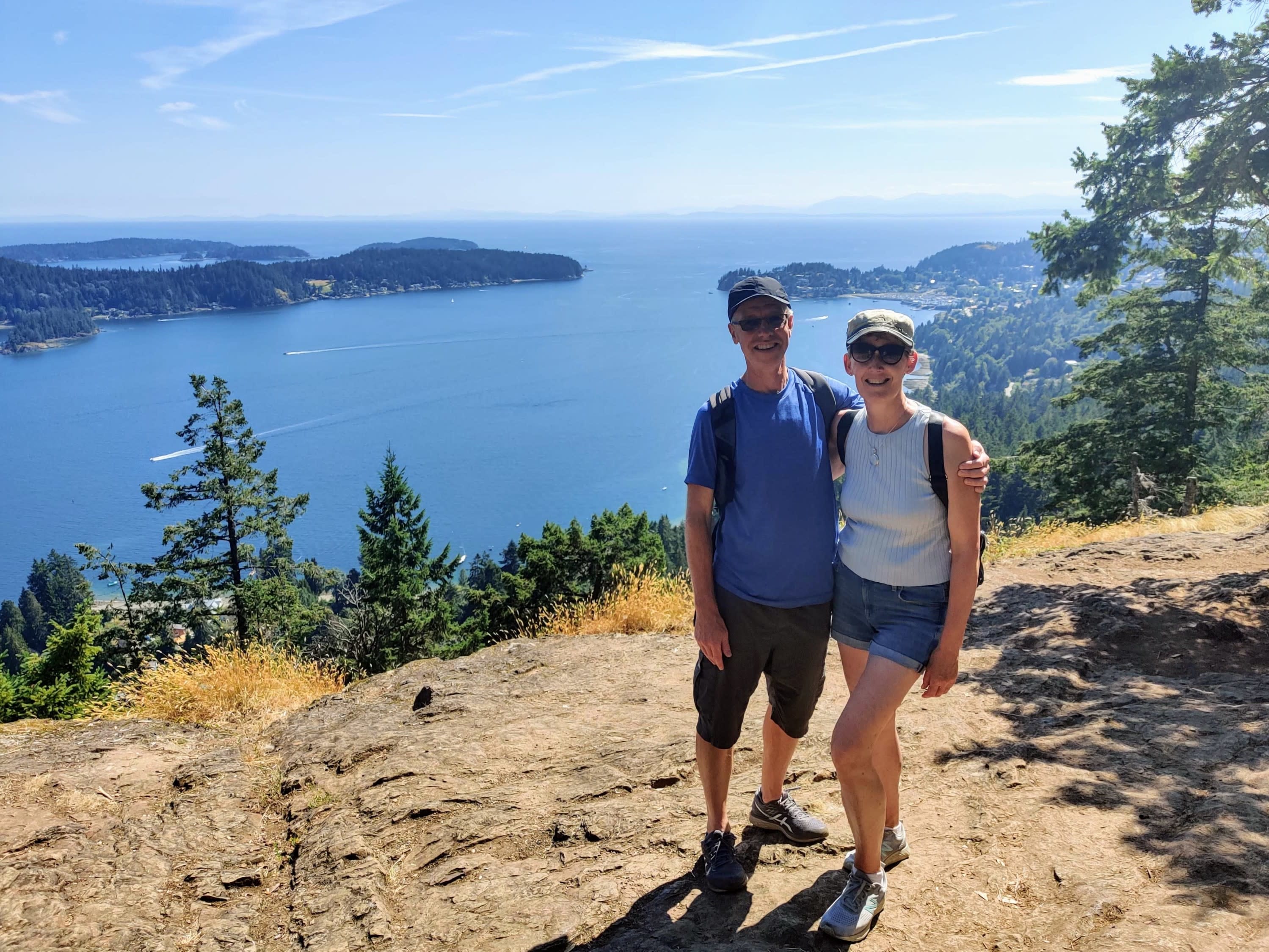 Warren and Gill McCulloch, Safe + Sound First Aid Training owners, standing on a high viewpoint in Sechelt, BC. in summertime