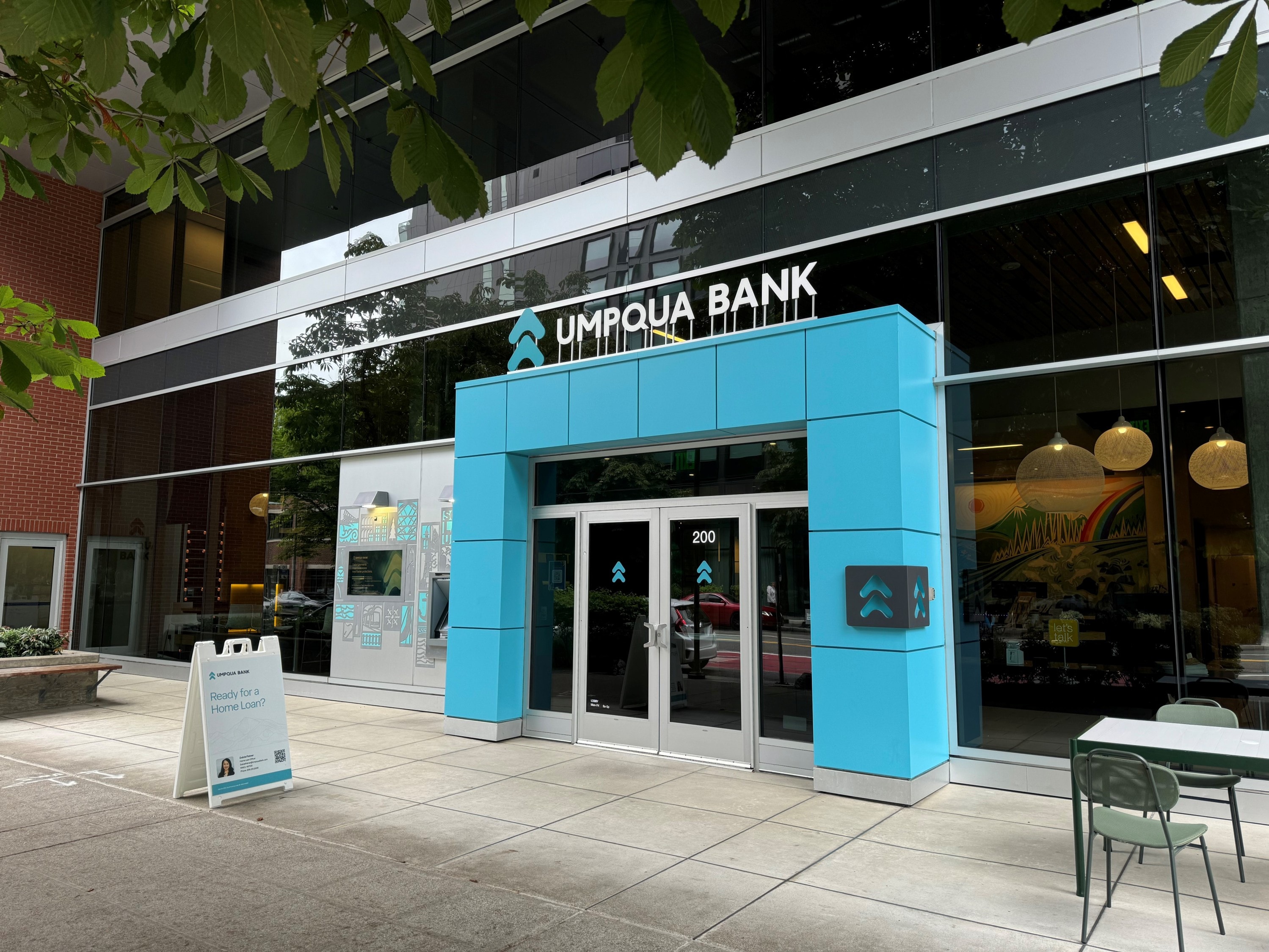 Umpqua Bank South Lake Union branch with modern glass exterior, blue entrance, and visible signage in Seattle.