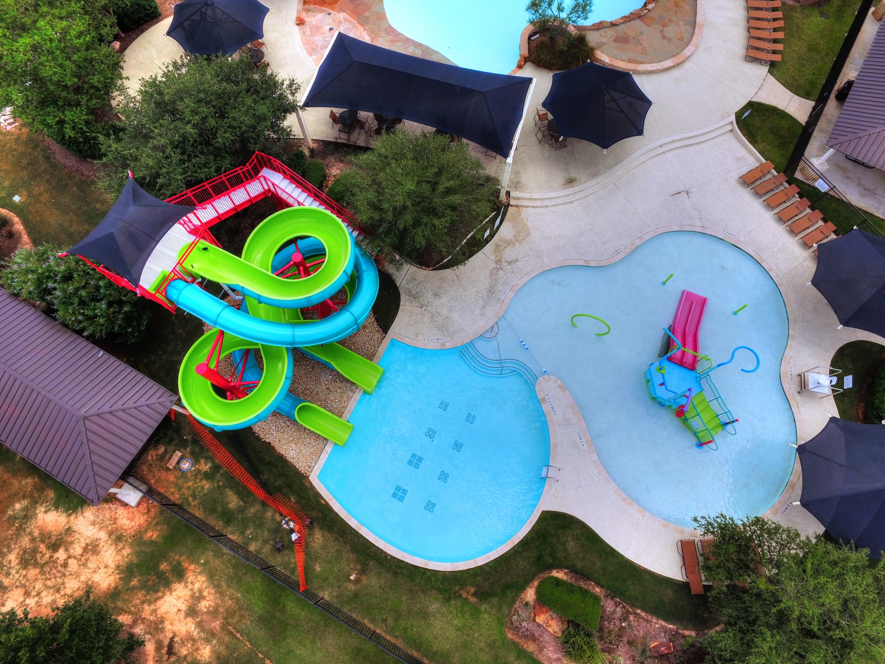 Commercial amenity pool with water slides and splash features at Firethorne subdivision, built by Sunset Pools in Katy, Texas