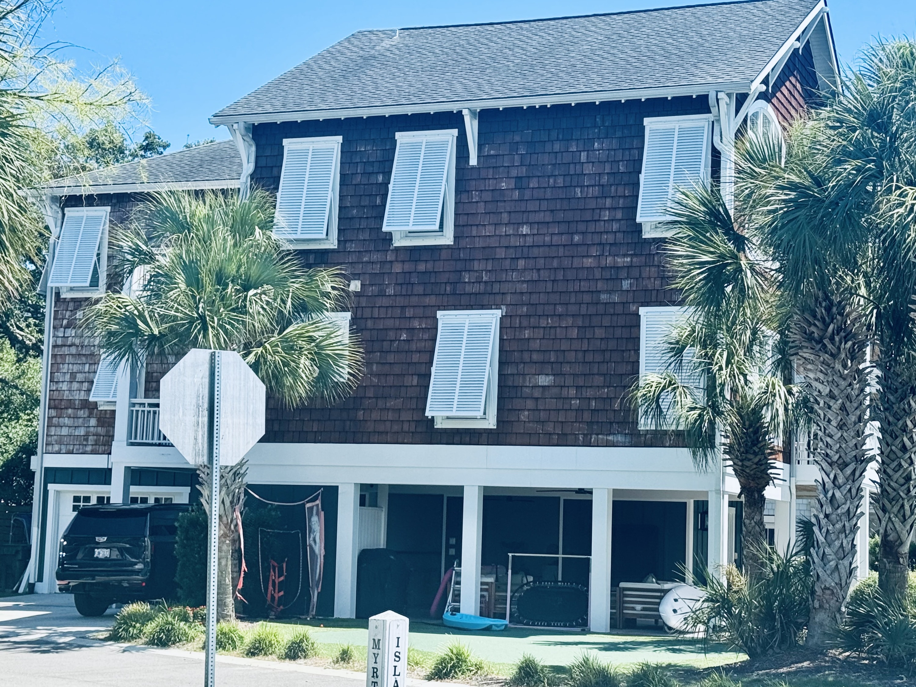 White bahama shutters on a home with cedar plank siding near Topsail Beach, NC