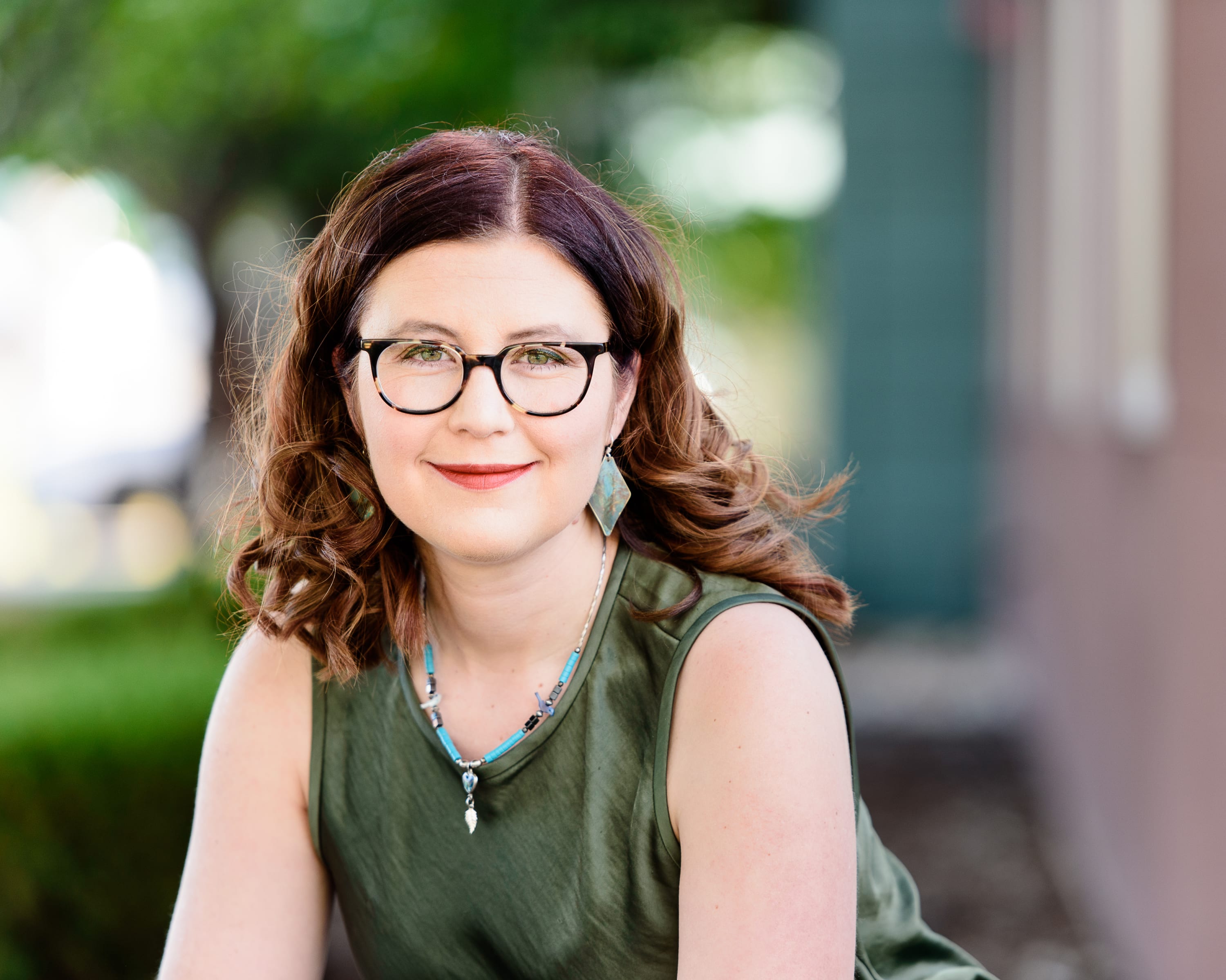 Image of Chelsea Adams in a Green shirt and glasses.