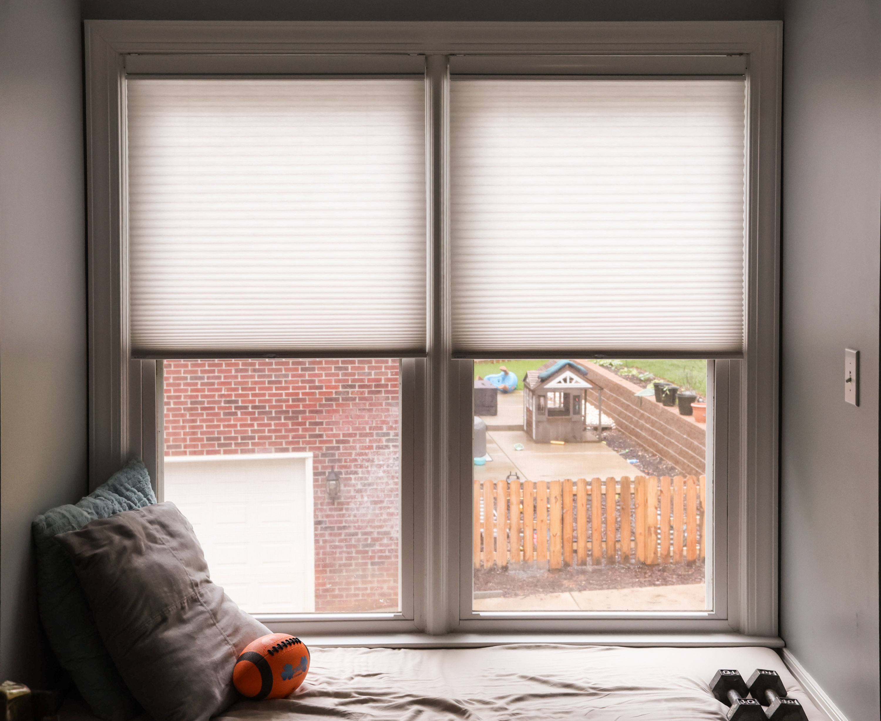 side-by-side honeycomb shades in bedroom nook