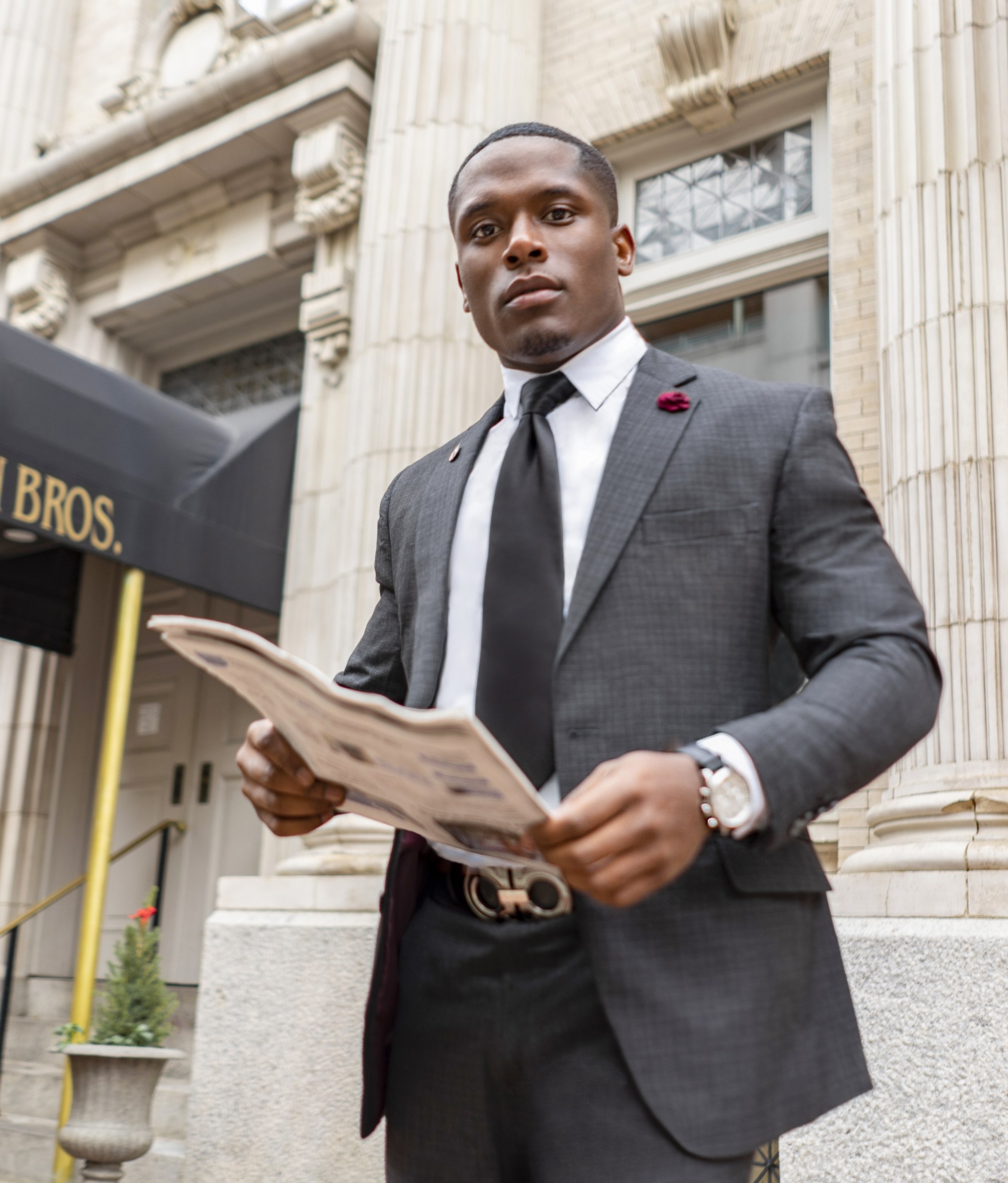 business man in a gray suit holding a newspaper
