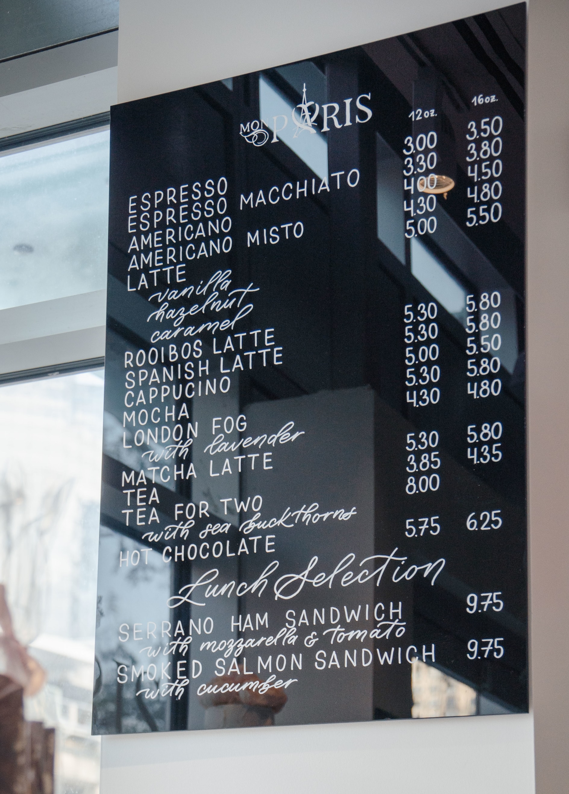 hand-painted cafe menu on black acrylic board with white letters