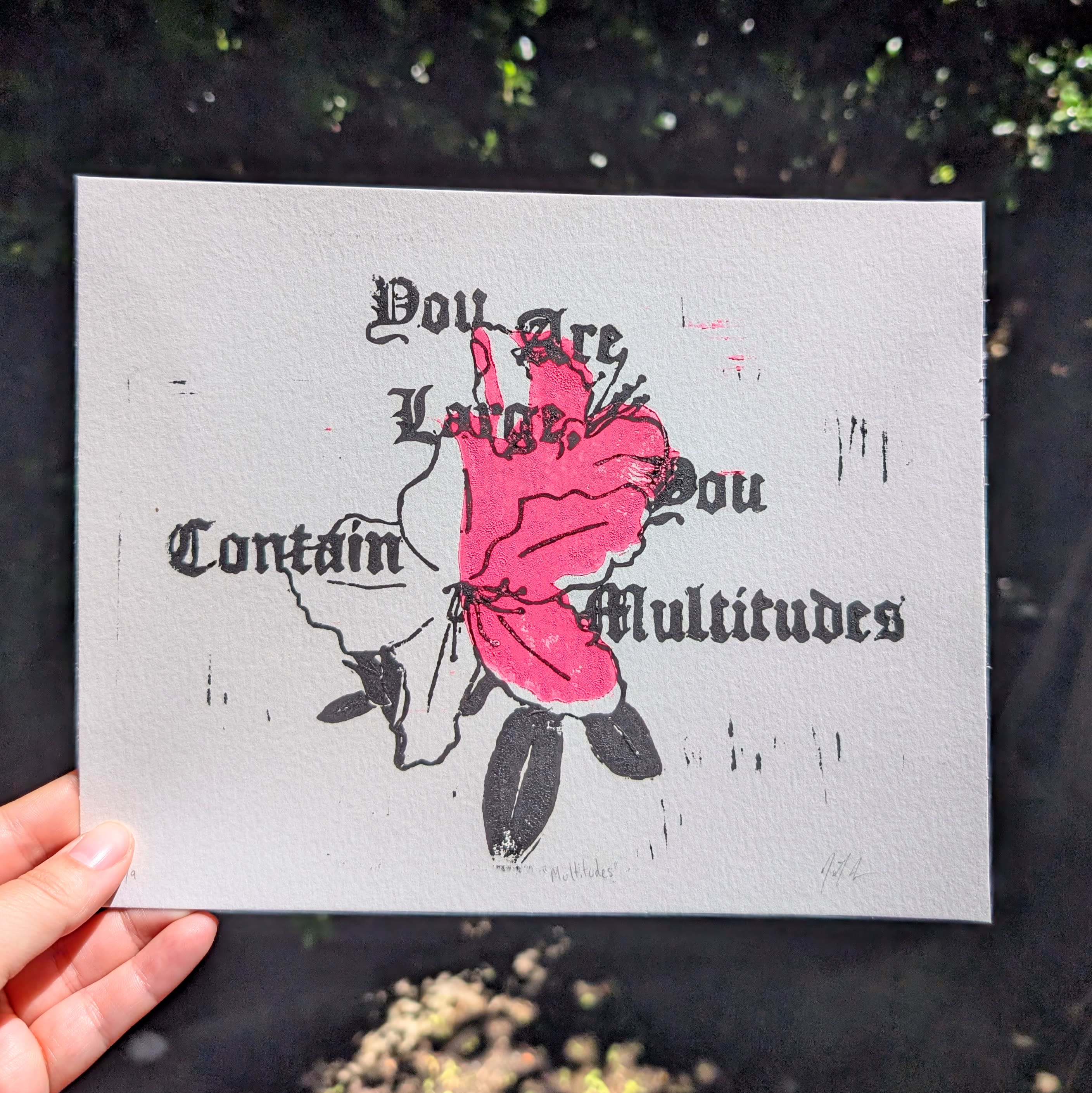block print with black and pink ink. Shows a two color rhodedendron and says "You are large, you contain multitudes"