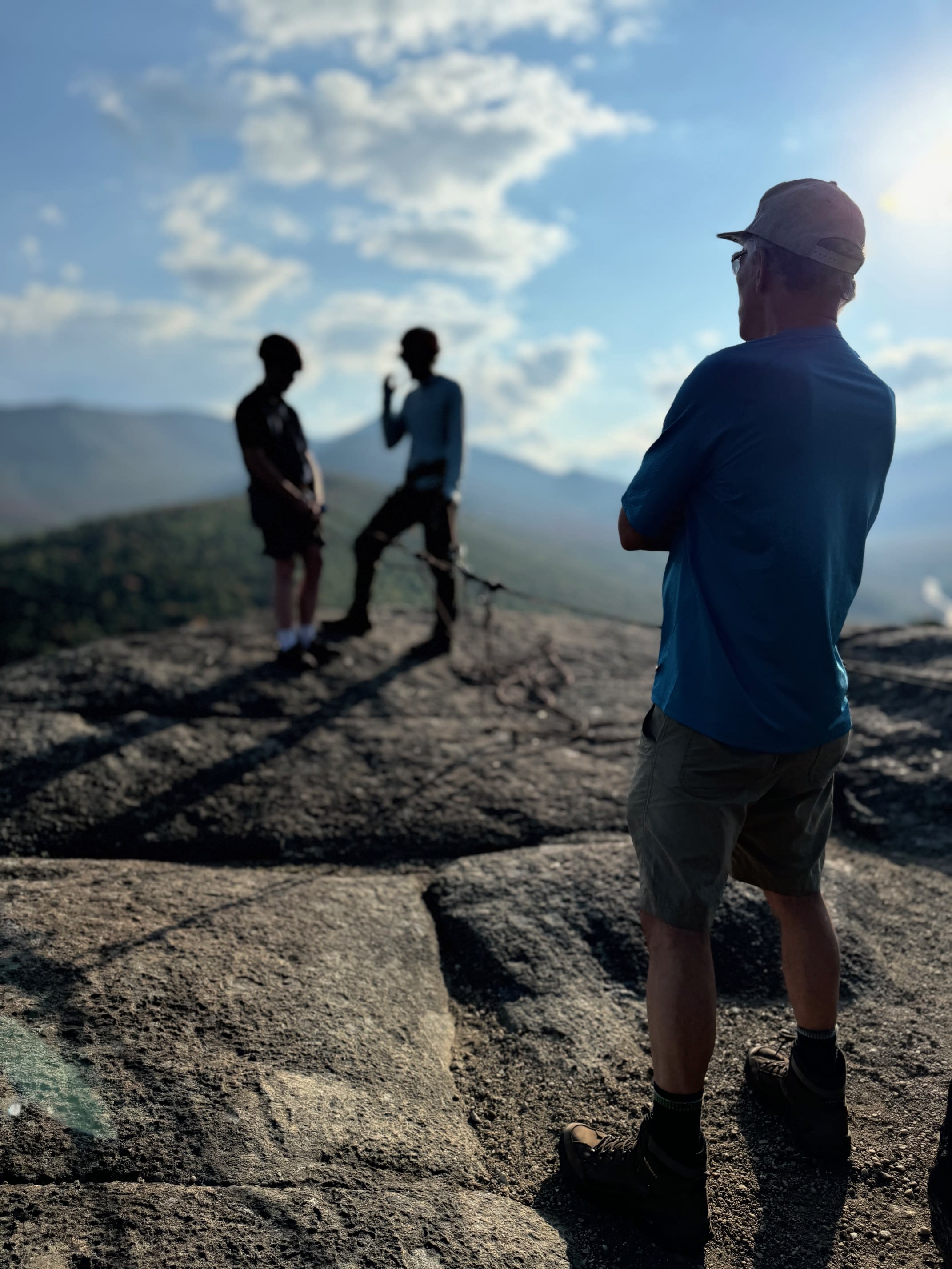 Staff teach students safe climbing techniques on a rocky ledge.