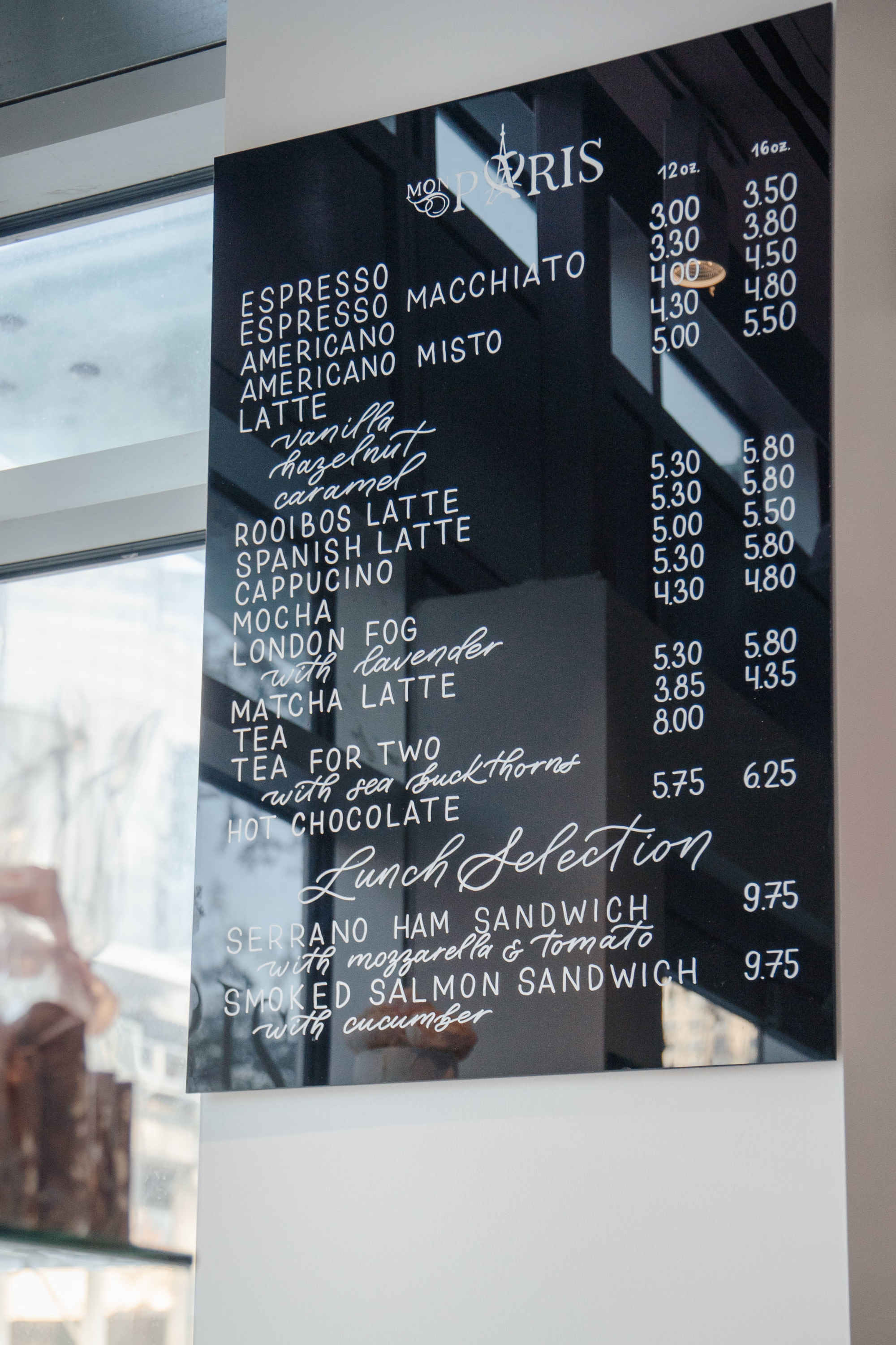 Hand-painted menu for cafe on black acrylic sheet with white letters