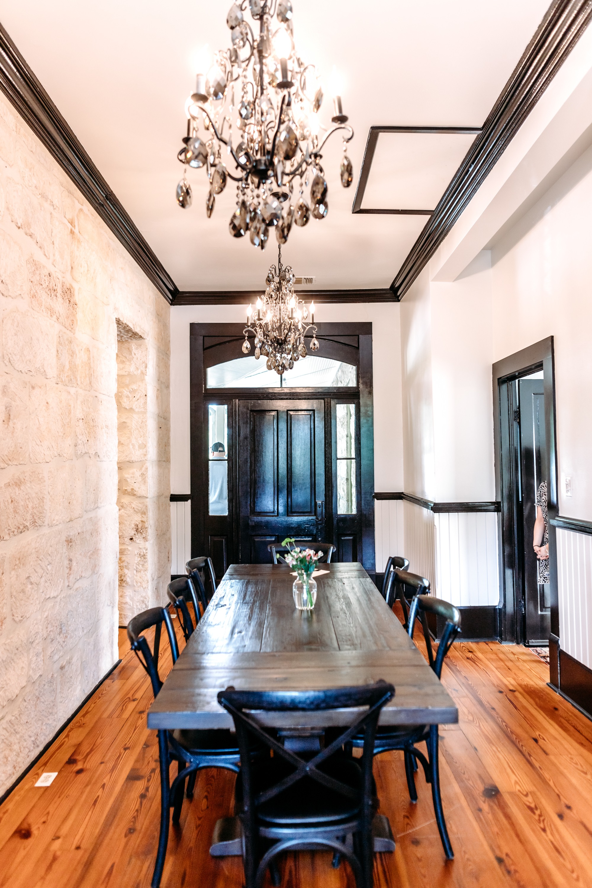 dining table with 8 chairs under two chandeliers