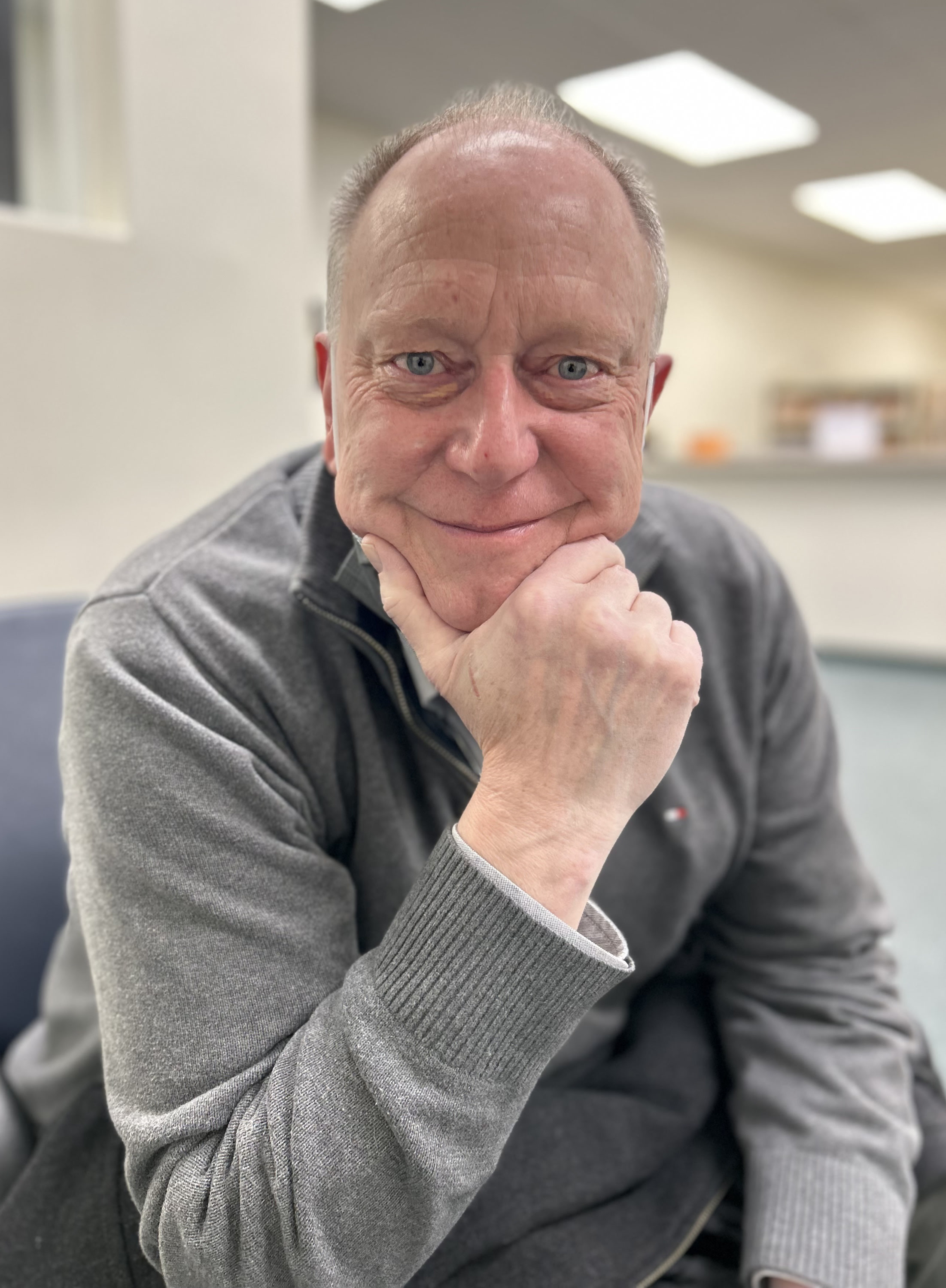 Portrait of Stewart Woodward smiling with chin on hand