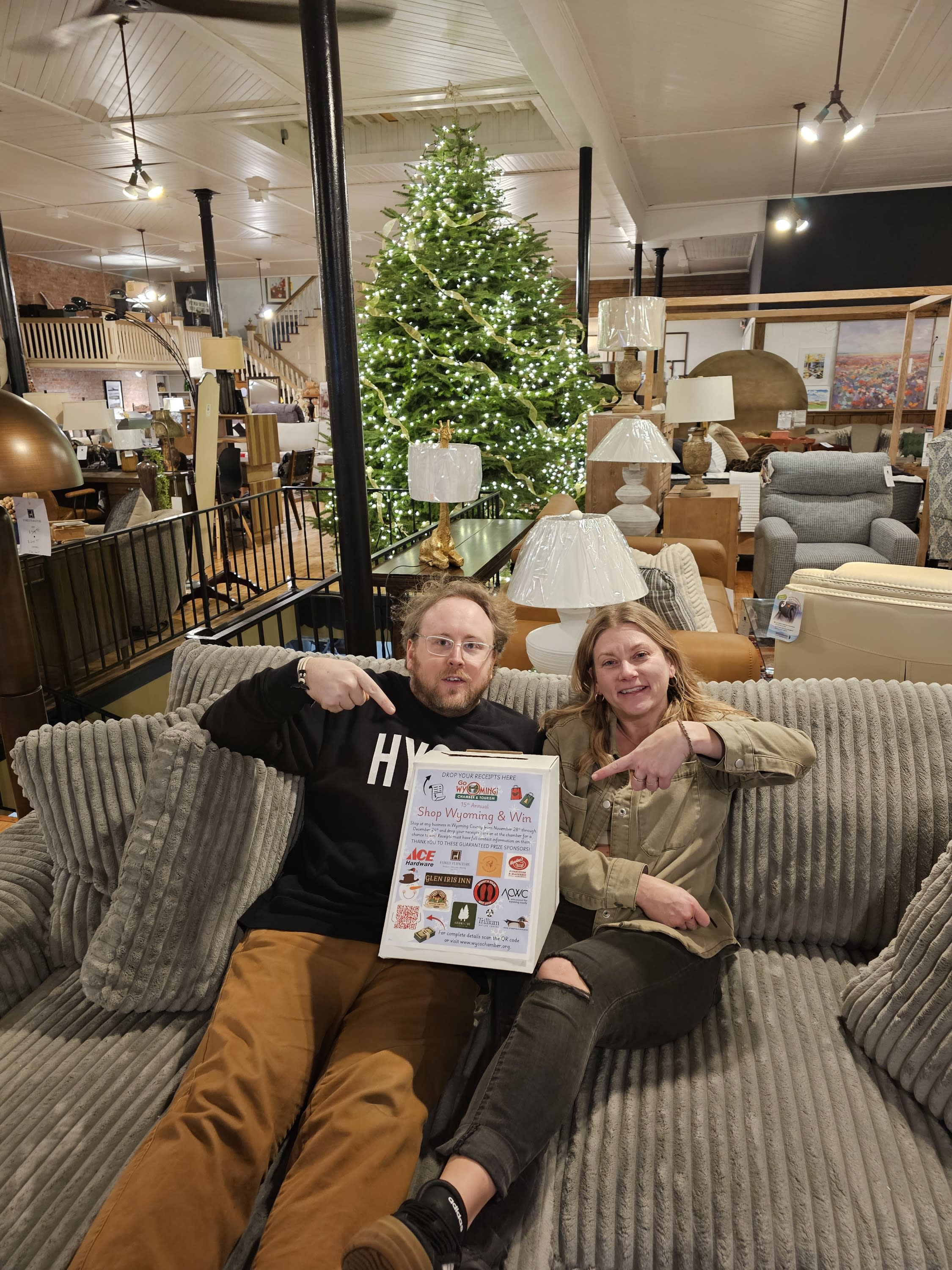 two people sitting on a couch in family furniture with the show wyoming and win box