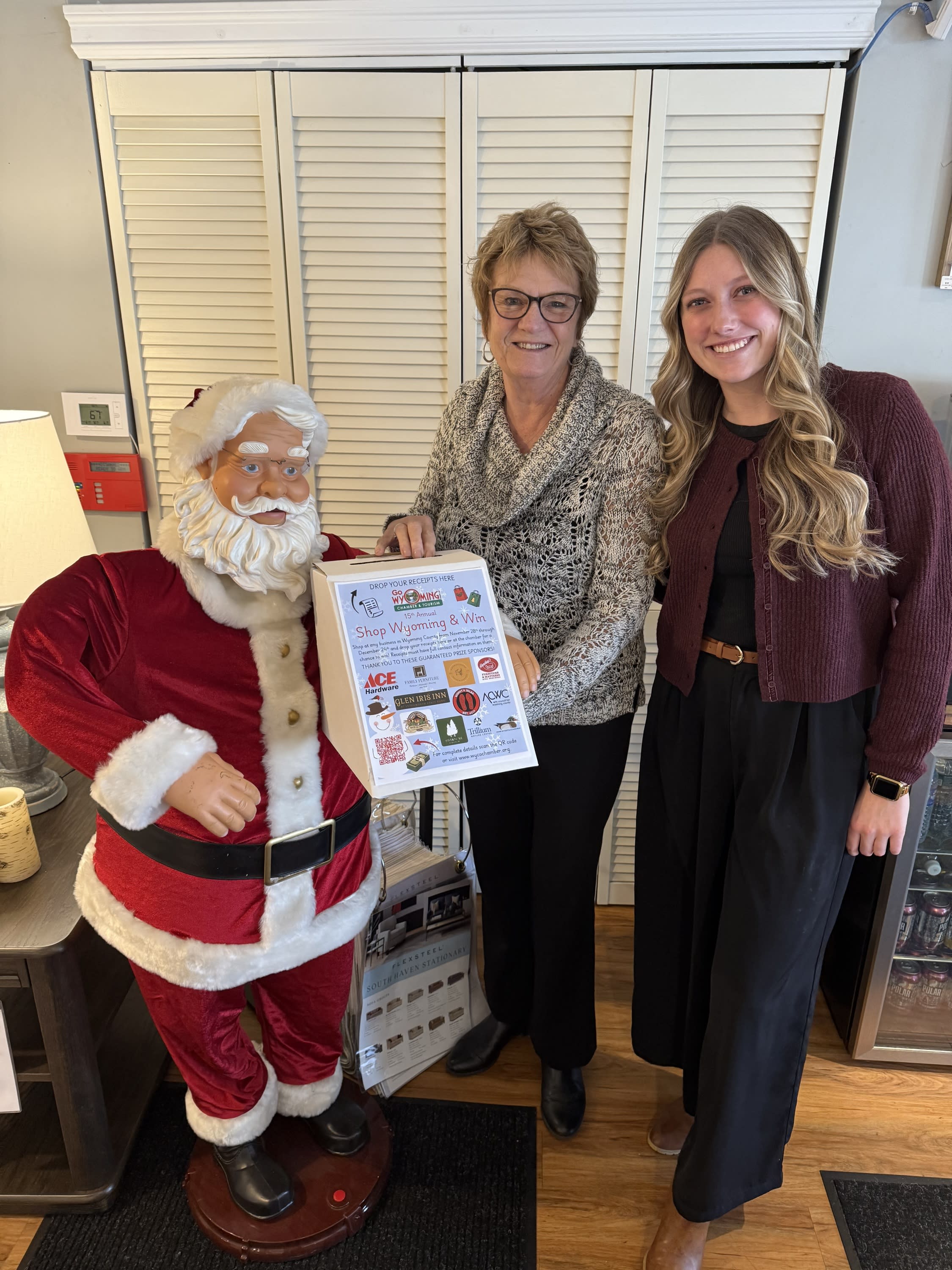 two people holding the shop wyoming and win box next to santa figure