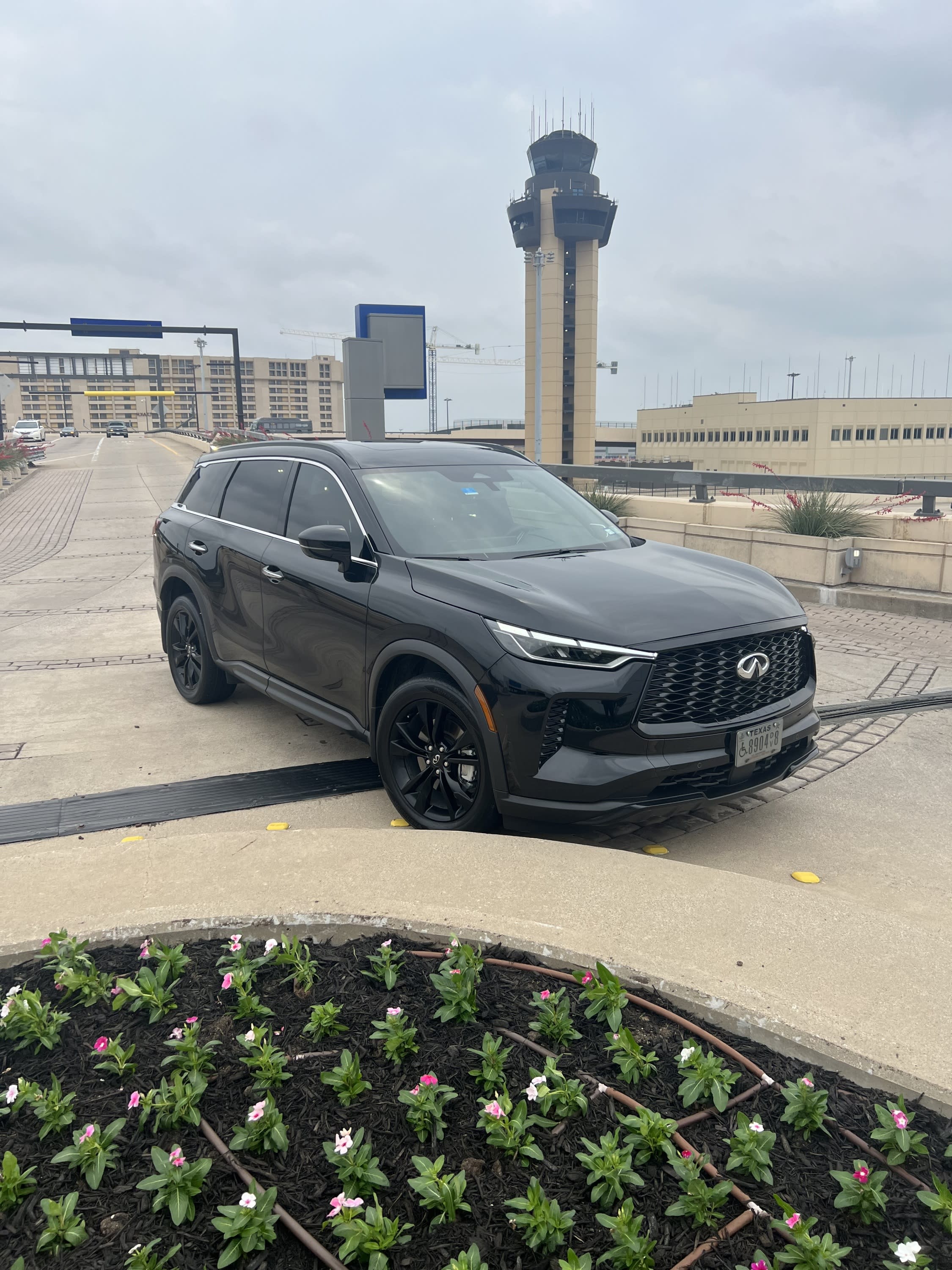 Blacked out QX60 parked on the curb at terminal D with one of the majestic Air Traffic Control tower in background.