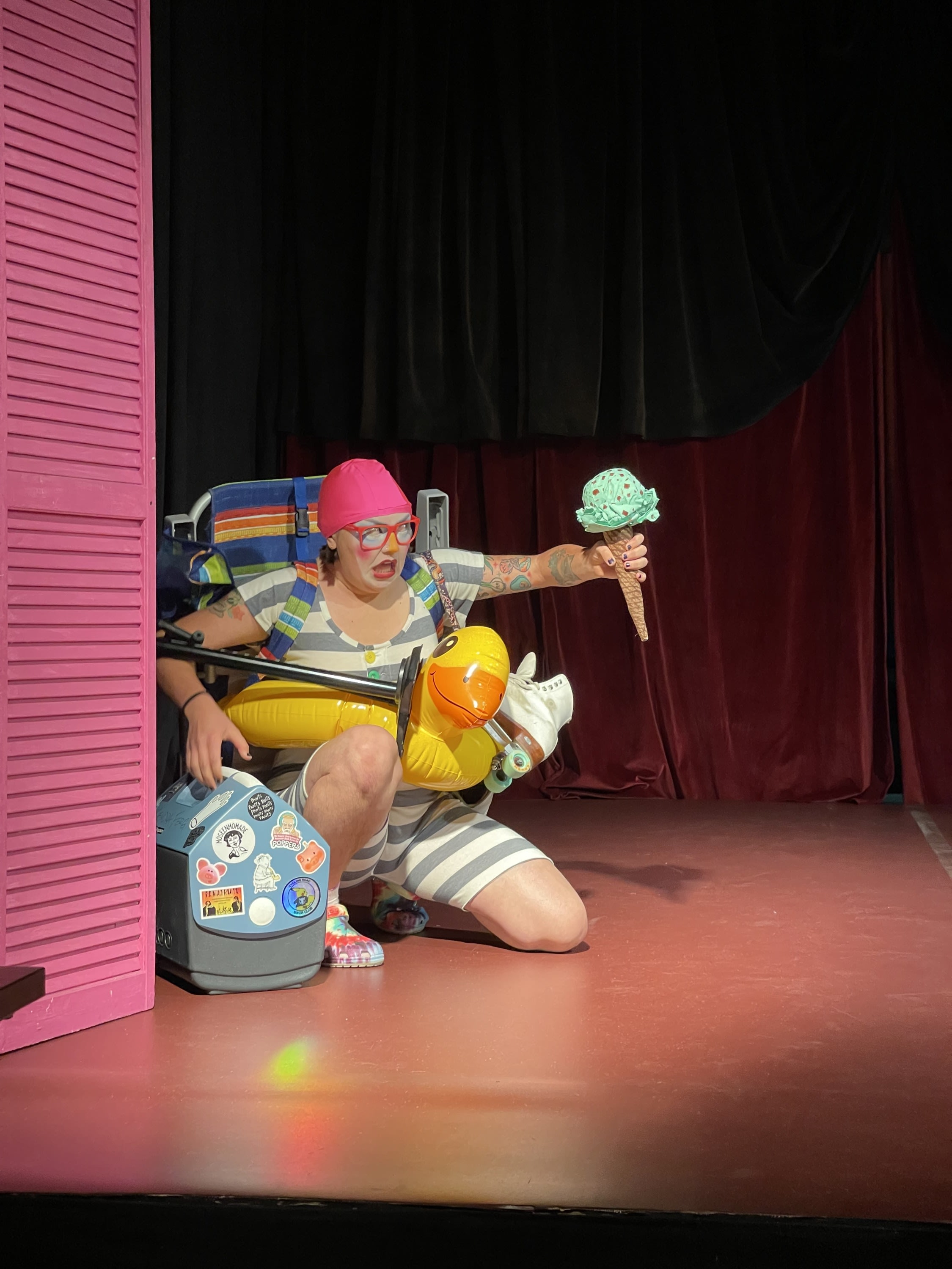clown with a giant ice cream come and cooler carrying other beach gear