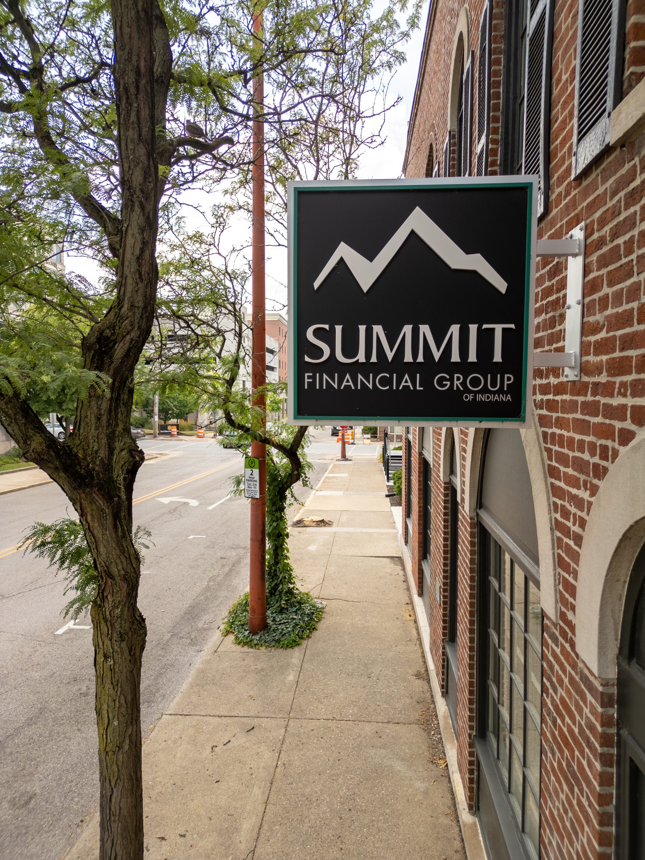 "Street view of Summit's sign on a brick building, featuring a mountain logo above the company's n