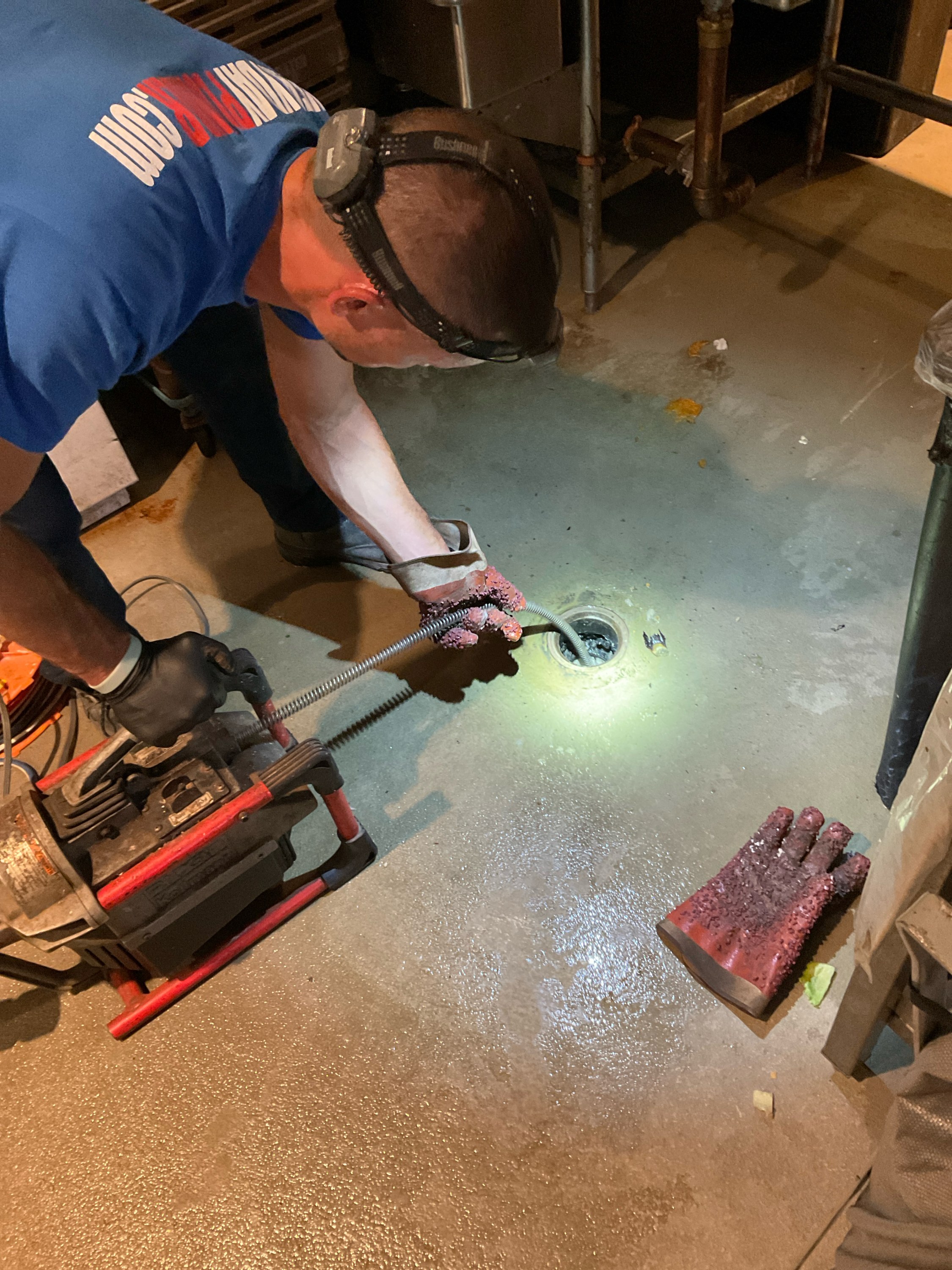 EVERYDAYPLUMBER.com technician clearing a floor drain with a drain cabling machine in St. Petersburg