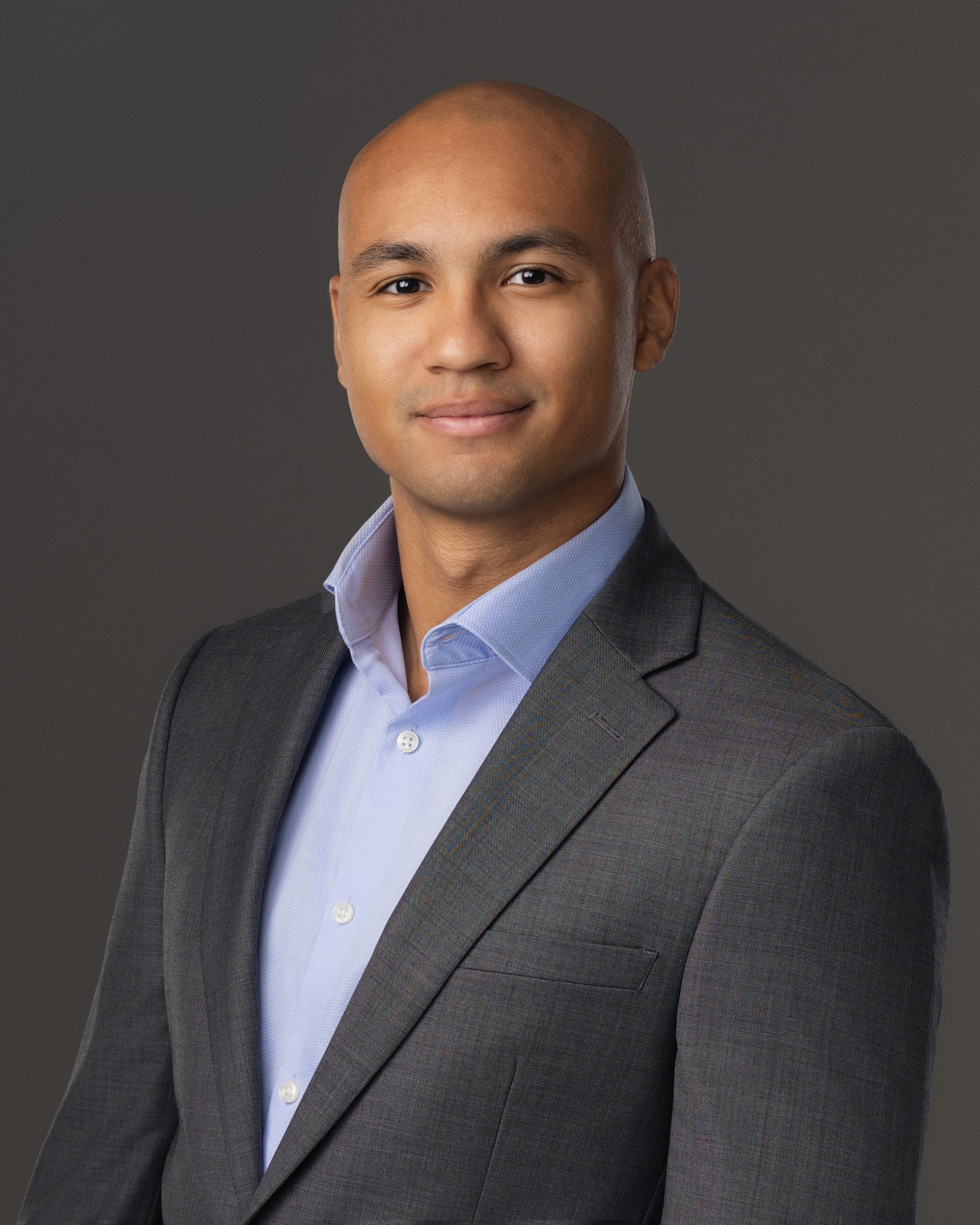 man in grey suit posing for headshot