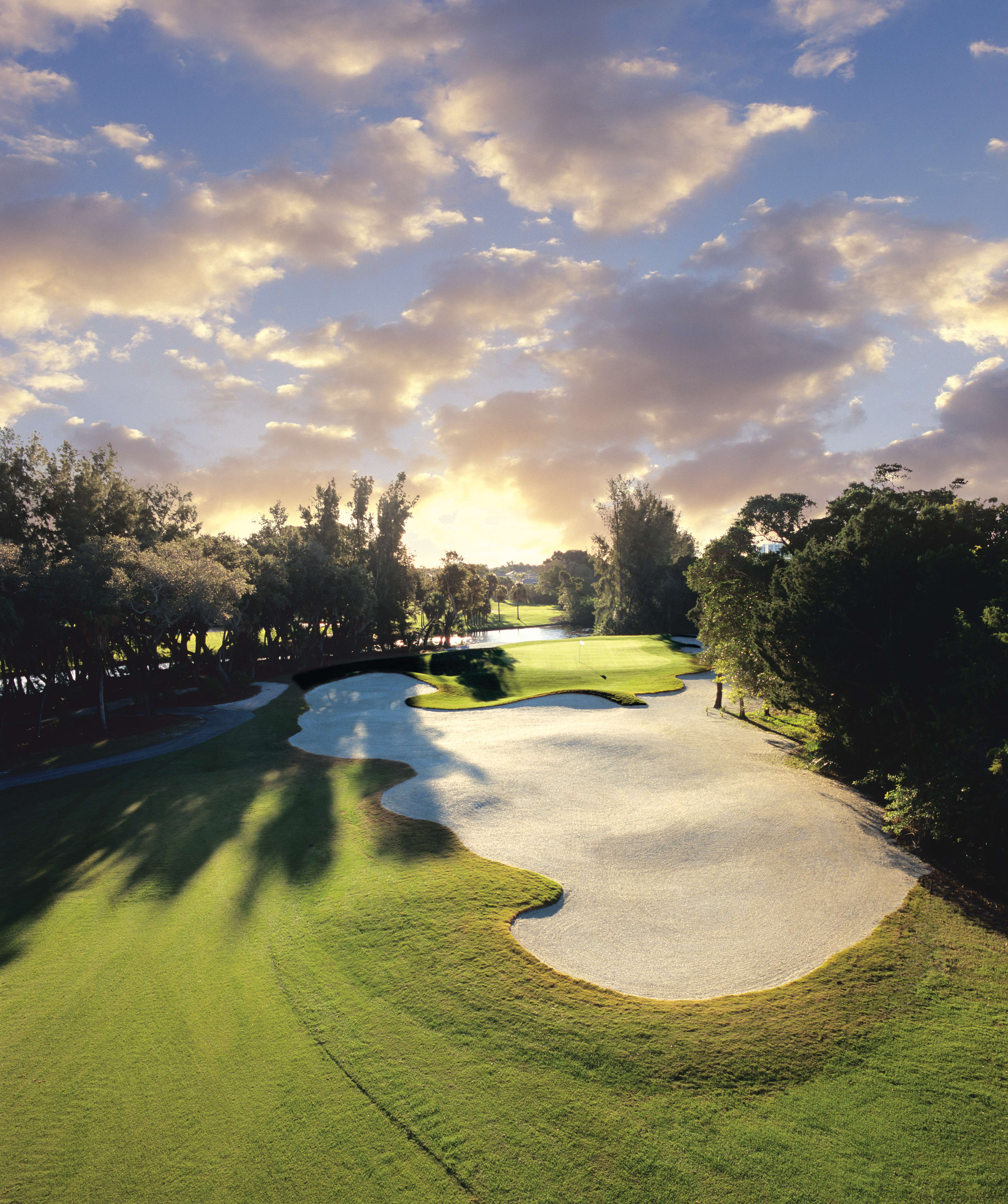 Sunset behind golf course with large sand trap