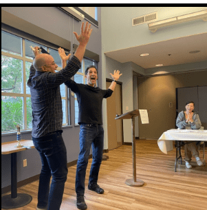 Two men with their arms in the air