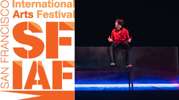 Actor Shaun Blaney sits atop a dark wall that is backlit by neon red and blue