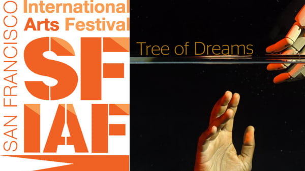 The hand of a wooden puppet or marionette reaches through a watery barrier to reach out to a human hand extended