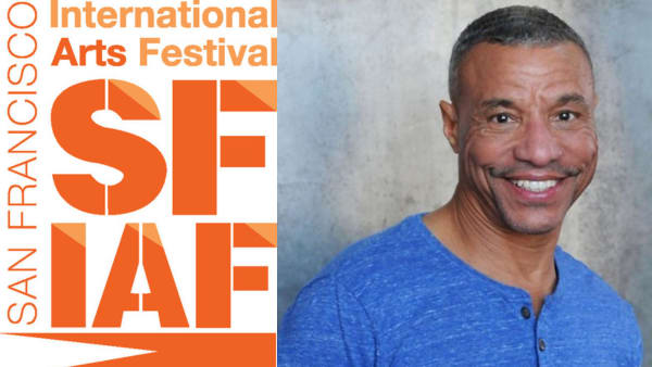 Algiin standing with a broad smile on his face against a blank wall