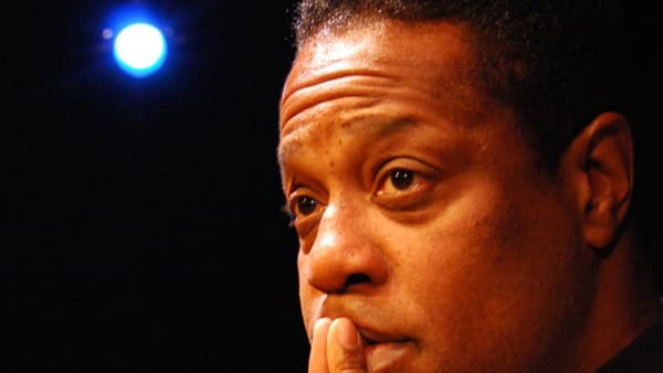 actor holds fingers to his lips