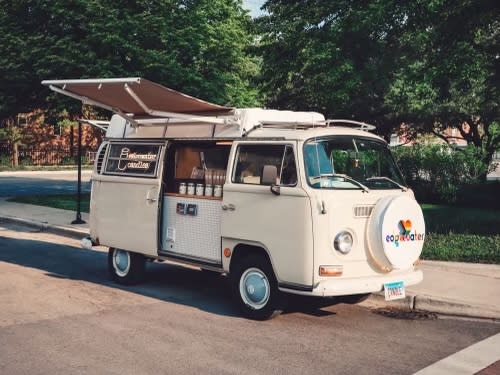 The Candle Camper as seen at a street festival. License plate "CANDLE"