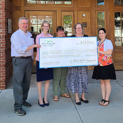 BHBT employees presents a donation from the Bank's Casual for a Cause program to NH Audubon.