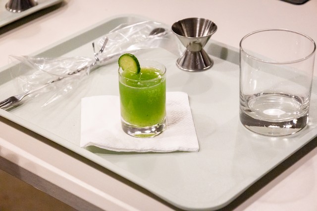 A neatly arranged tray featuring a small green ENAB garnished with a cucumber slice, placed on a white napkin.