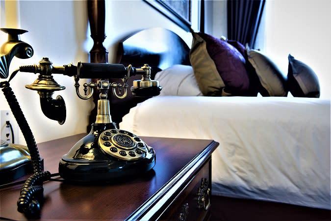 Vintage phone and king bed in a suite at Hotel at Old Town