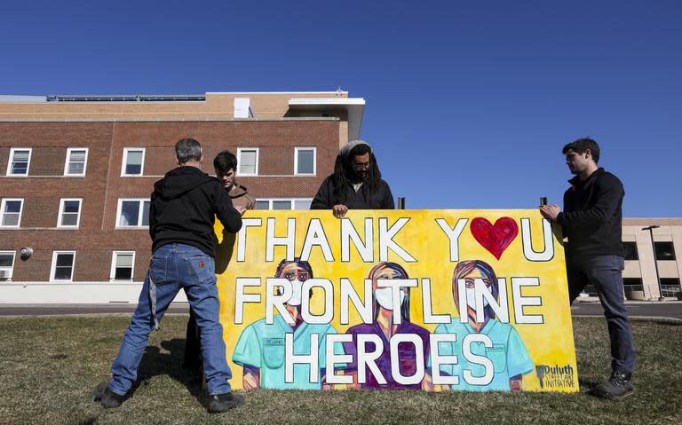 From left: Judge Shaun Floerke, Cole Floerke, Sean Moore and Connor Floerke install a 4-by-8 foot painted sign in front of St