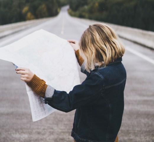 Woman reading map, symbolizing "!0 Better Questions to Ask Your Financial Planner in Omaha"