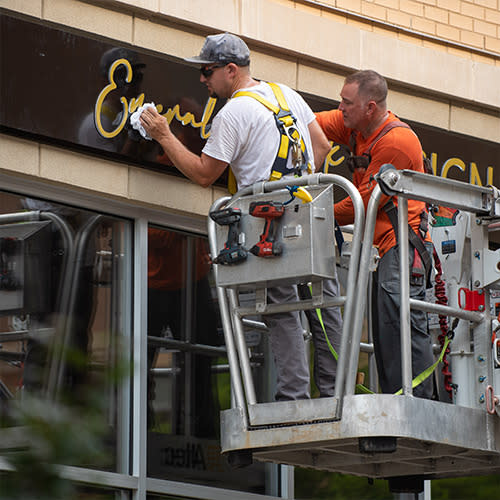 Sign installers cleaning a new sign