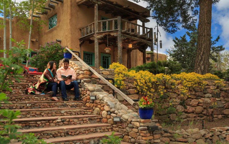 Couple reading a book on the steps of the Inn with spring flowers