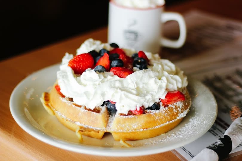 Golden Malted Waffle topped with fresh strawberries, blueberries and whipped cream.