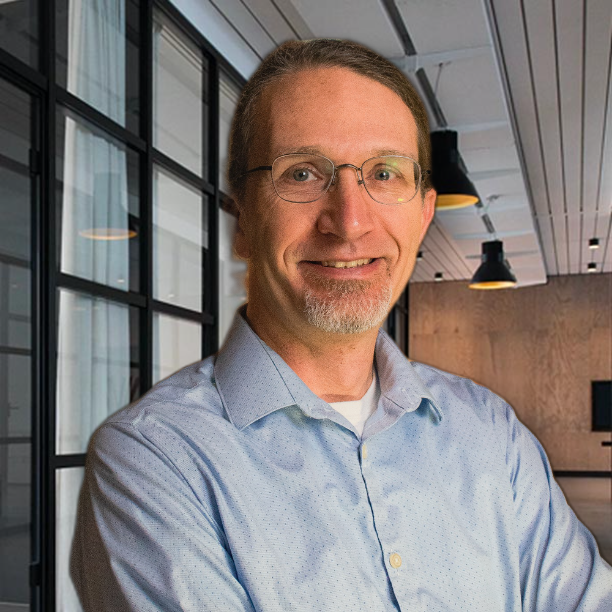 Smiling man in light blue dress shirt in an office
