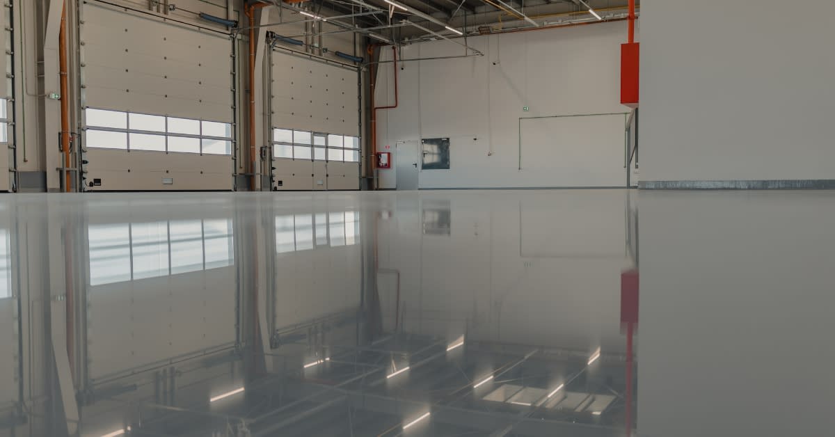 High-gloss industrial epoxy flooring in commercial warehouse bay – seamless chemical-resistant finish