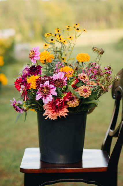 A bucket with bold colored flowers