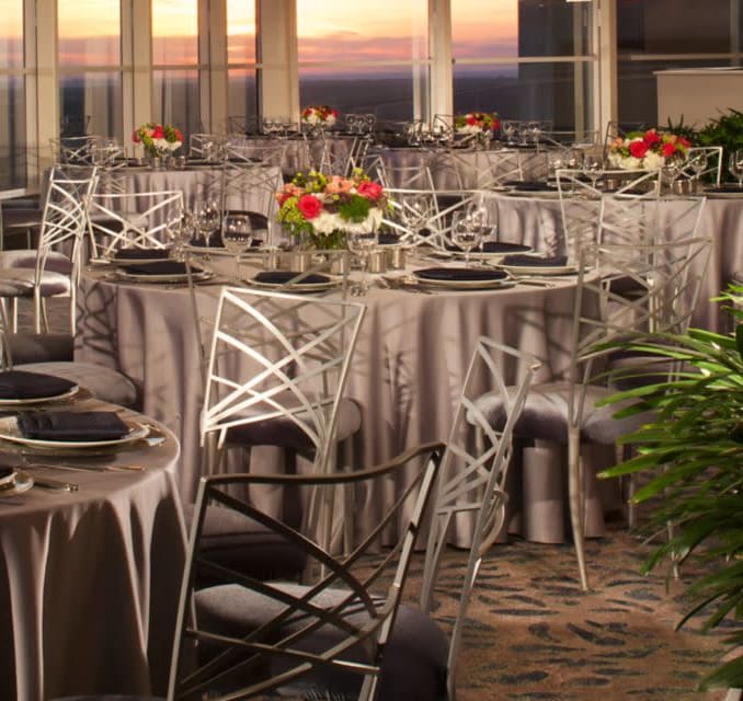 Silver round dining tables by window overlooking Dallas skyline