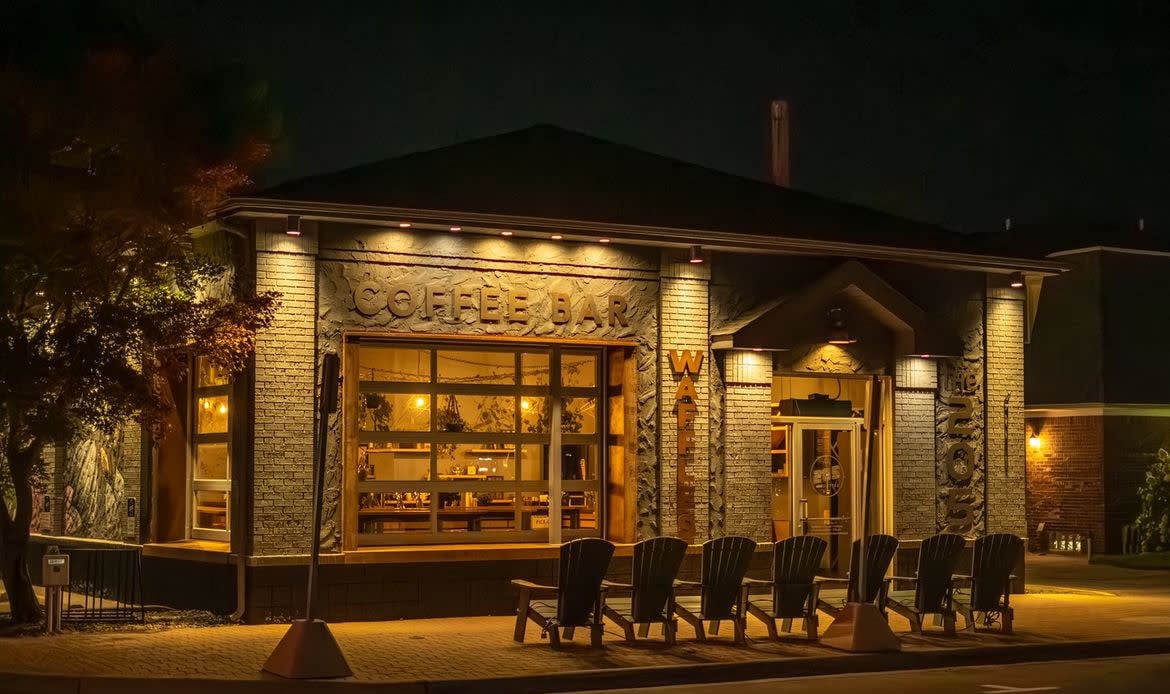 The front of the 205 coffee bar lit up at night with warm lighting