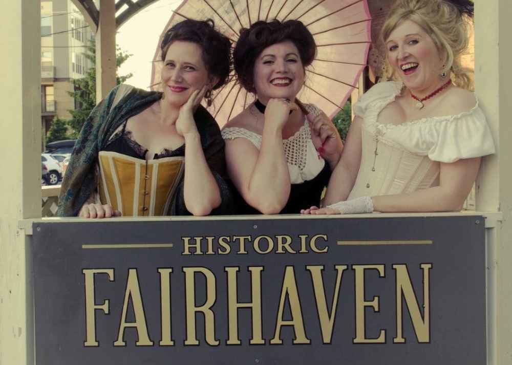 Three Good Time Guides dressed in corsets and gilded age undergarments pose in the Historic Fairhaven Gazebo.