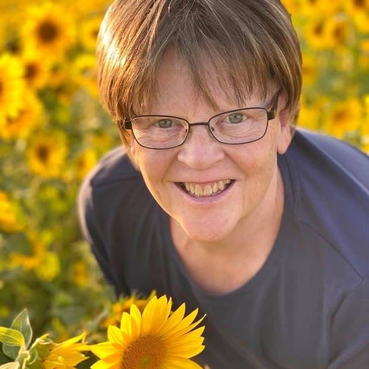 woman standing in a field of sunflowers