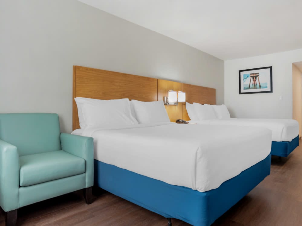 hotel room with two queen beds and a chair