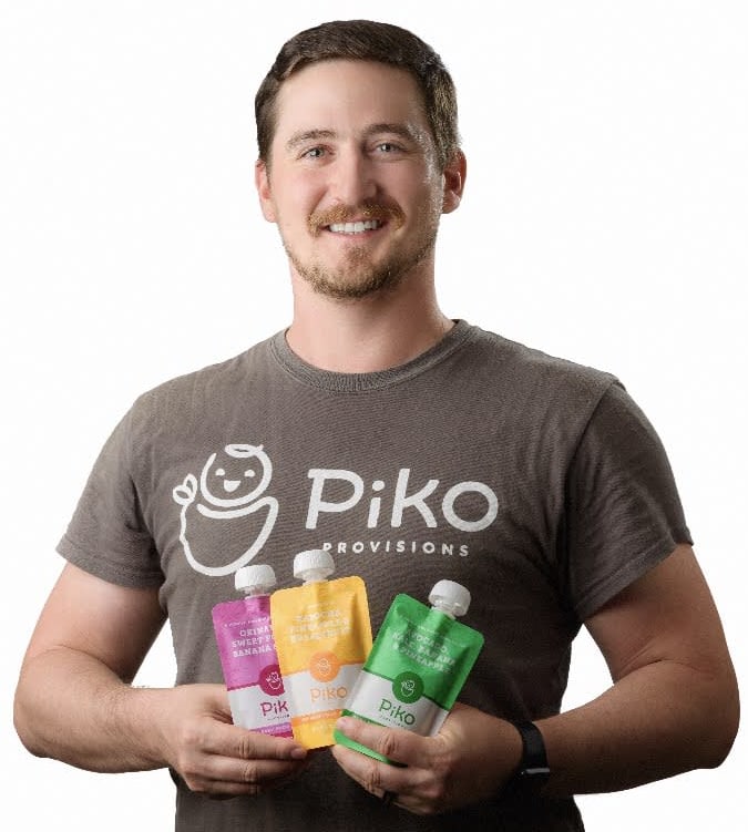 Ethan West holding three pouches of Piko Provisions baby food