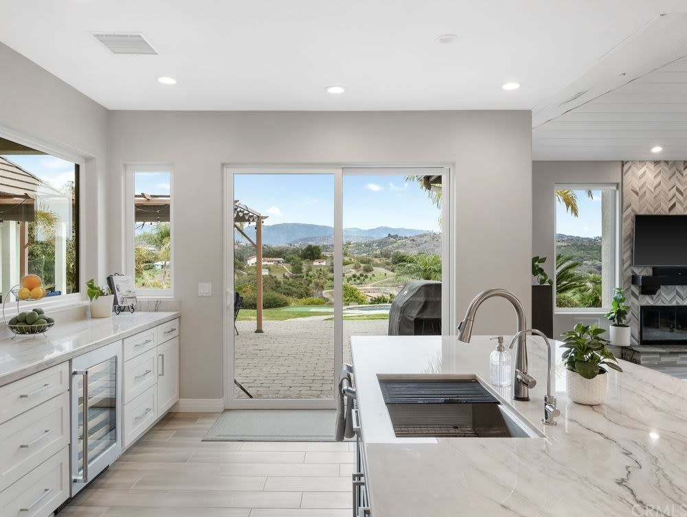 Light, bright kitchen with double paned windows, sliding patio door, and white casing and trim on the whole house.