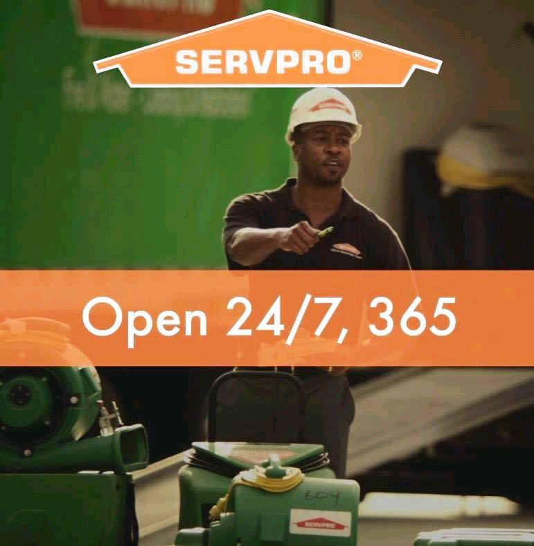 SERVPRO Technician standing in warehouse and text saying Open 24/7, 365