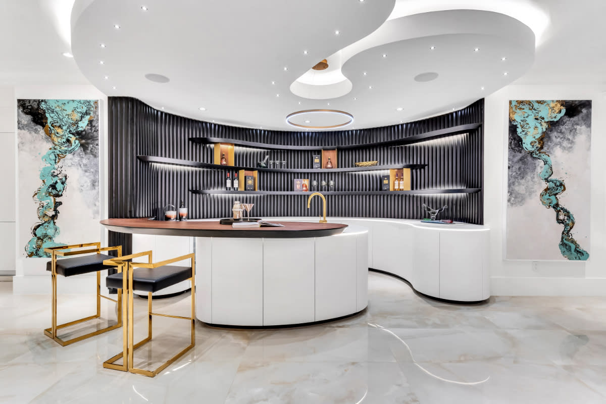 Luxury millwork in a contemporary bar with curved cabinetry and shelving.