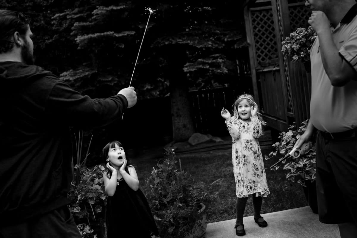 documentary photograph of two little girls reacting in fright to a lit sparkler