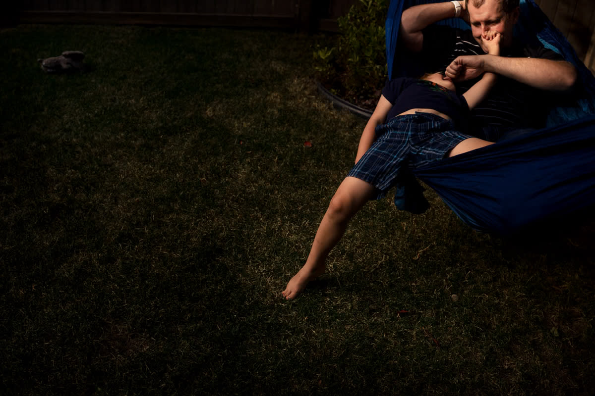 documentary photograph of a father-son moment on the hammock pinching eachothers' noses